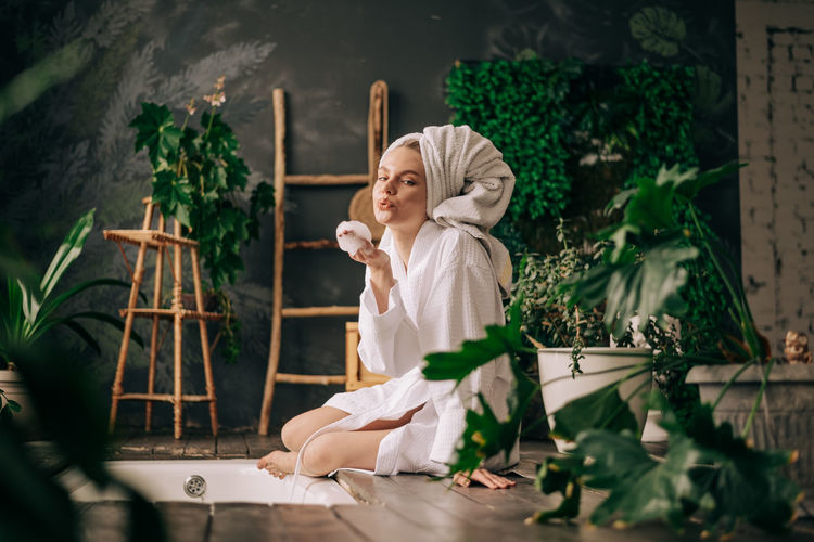 Young woman in bathroom wearing bathrob and towel indoors lifestyle. skin care and wellness concept