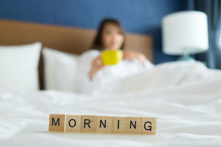 Close-up of morning text with woman in background