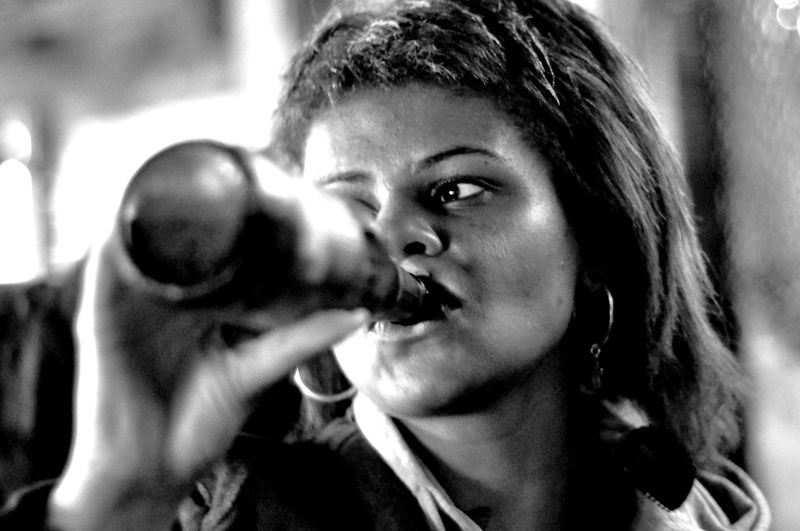 Close-up of mid adult woman drinking beer 