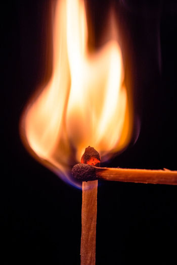 Close-up of illuminated matchstick against black background