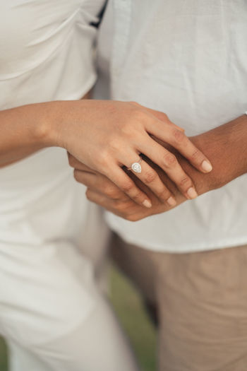 Midsection of couple holding hands
