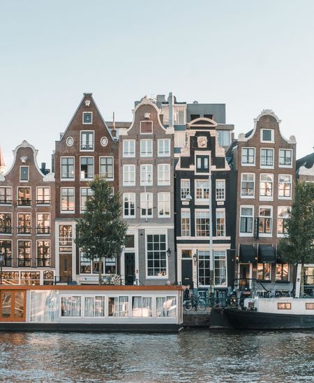 Buildings by river against clear sky