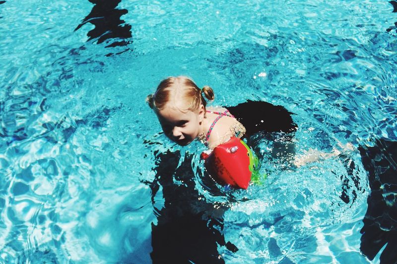 Happy girl swimming in pool