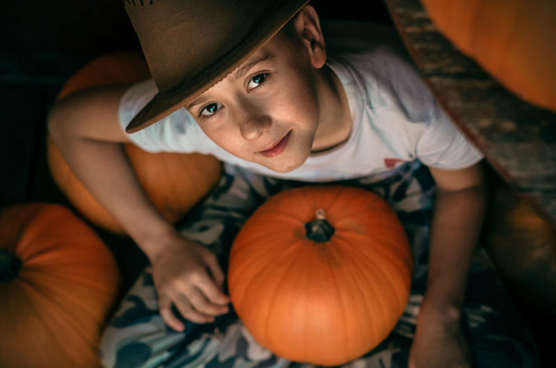 High angle view of man sitting by pumpkin