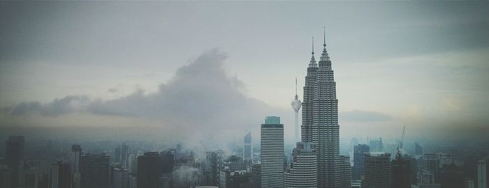 Panoramic view of petronas towers amidst buildings in city