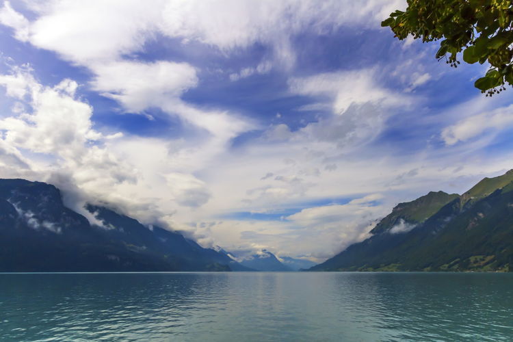Scenic view of lake by mountains against sky