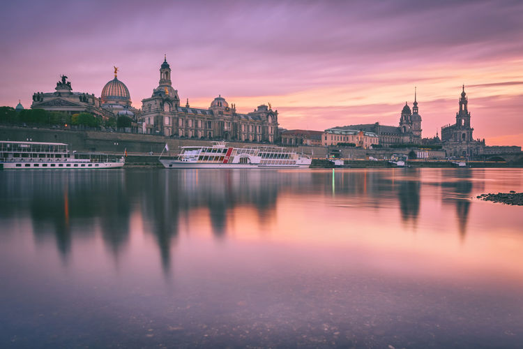 Bruhl terrace by river against sky during sunset