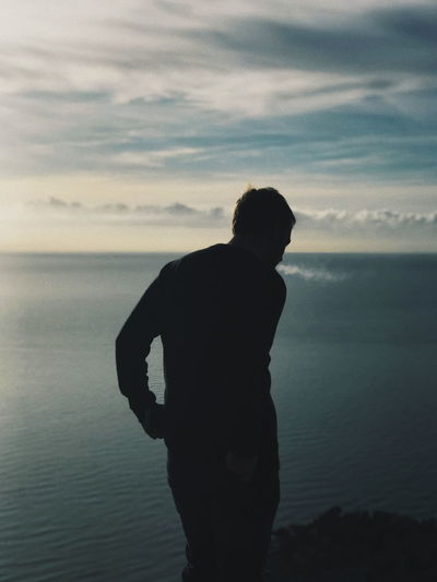 Silhouette of man looking at sea
