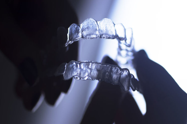 Close-up of hands holding plastic dentures