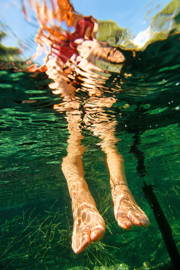 Underwater view of woman legs in plitvice lakes, croatia