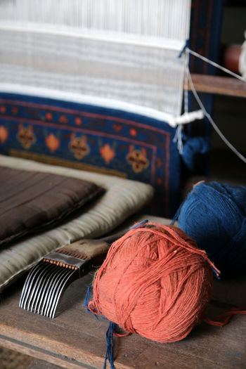 Yarn on workbench by loom weaving carpet at workshop