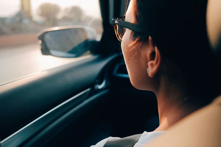 Woman wearing eyeglasses looking through car window