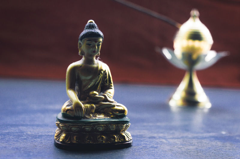 Close-up of buddha statue on table