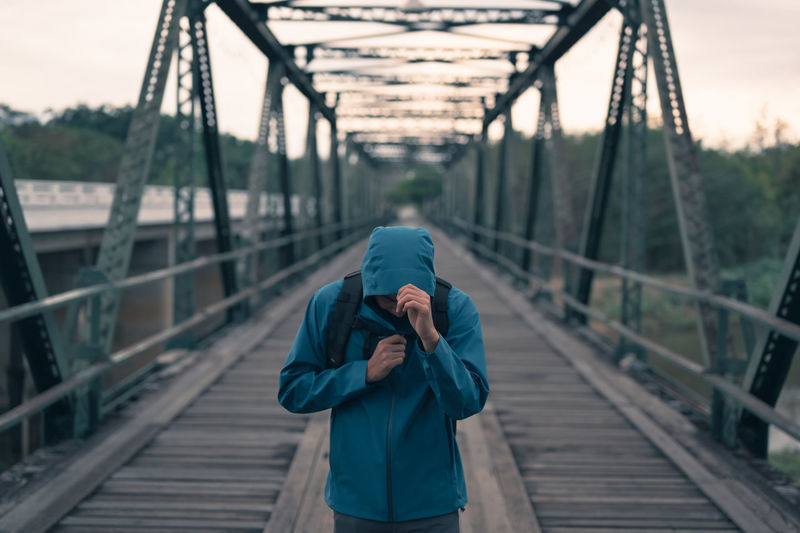 Young man wearing hoodie walking cross the bridge