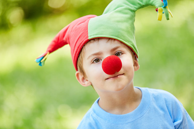 Close-up portrait of boy wearing hat and clown