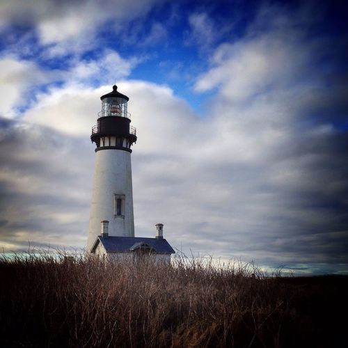 Low angle view of lighthouse on field against sky