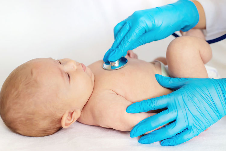 Hands of doctor examining baby patient in clinic