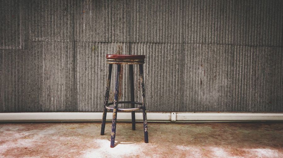 Vintage chair with galvanized wall and concrete floor background. copy space.
