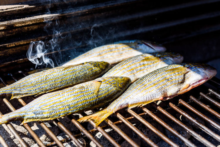 Close-up of fishes on barbecue grill