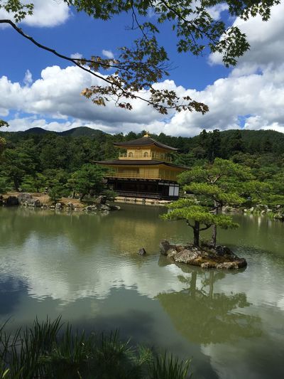 View of lake and buildings against cloudy sky
