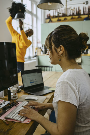 Female freelancer using computer while sitting at table working from home