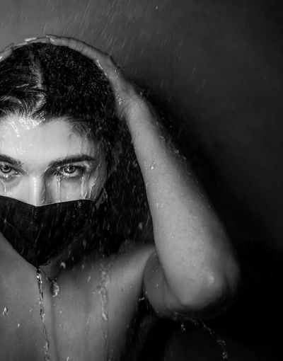 Close-up portrait of woman wearing protective face mask taking a bath