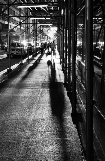 People on illuminated railroad station platform at night