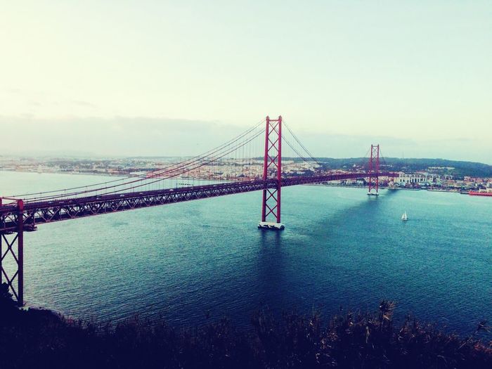 Suspension bridge over sea against sky