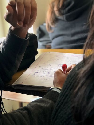 Low section of man and woman reading book on table