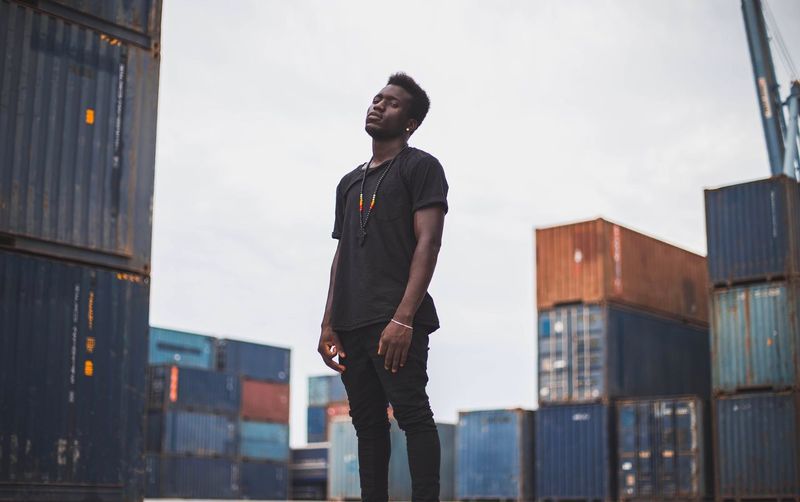 Low angle view of young man standing against sky