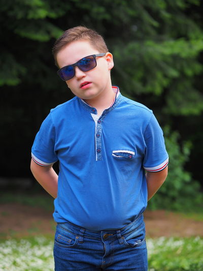 Portrait of young boy wearing sunglasses standing outdoors