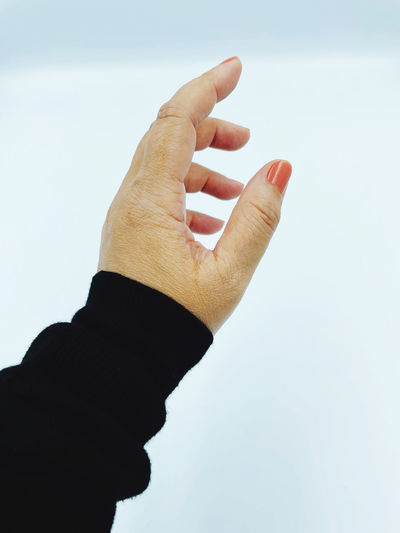 Cropped image of hand against blue background