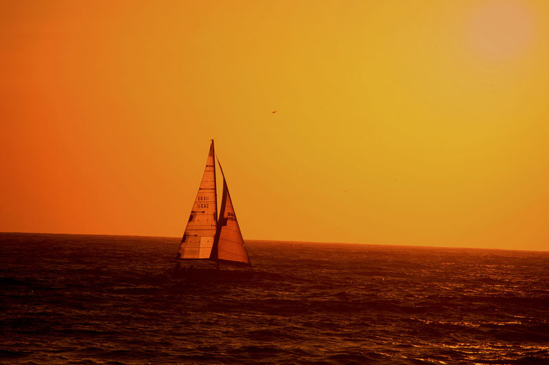 Silhouette of boat in sea at sunset