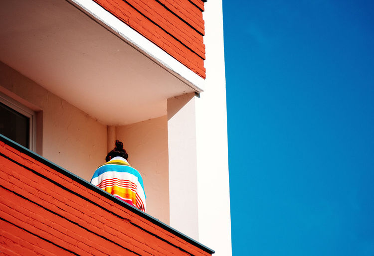 Low angle view of person standing on the balcony of building