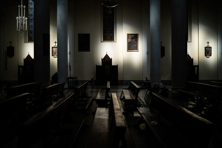 Empty chairs and tables in illuminated building