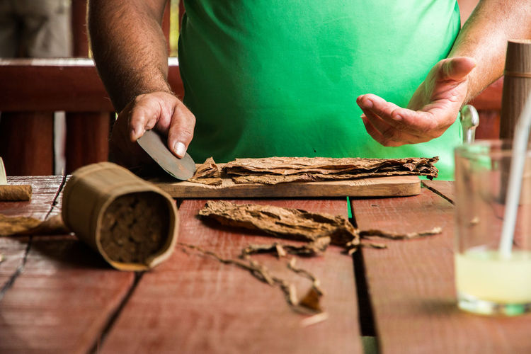 Close-up of man making cigar