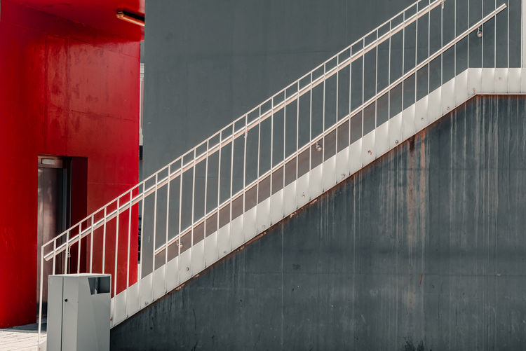 Red railing by wall of building
