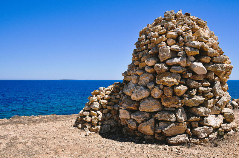 Stack of pebbles on beach against clear sky
