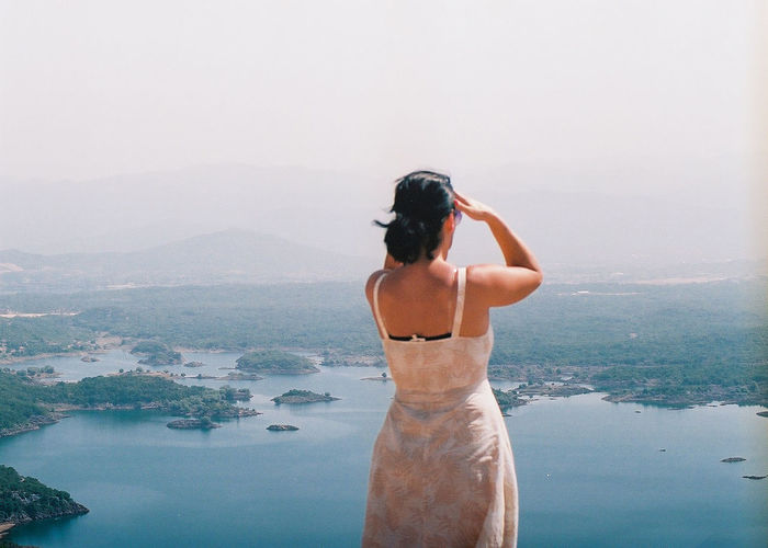 Rear view of woman looking at sea against sky