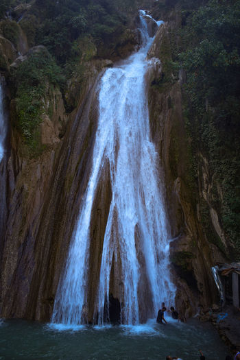 Scenic view of waterfall falling from mountain