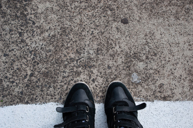 Close-up of shoes on road