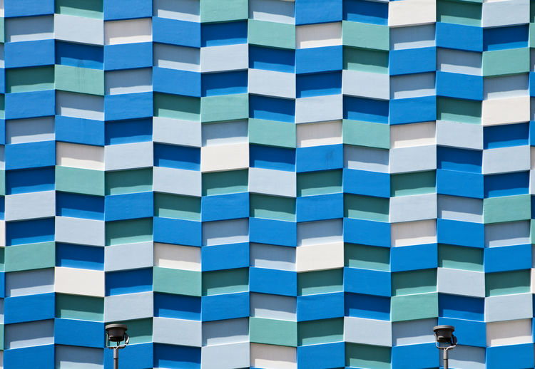 The exterior wall of an apartment tower is covered in an abstract pattern of rectangular shapes.
