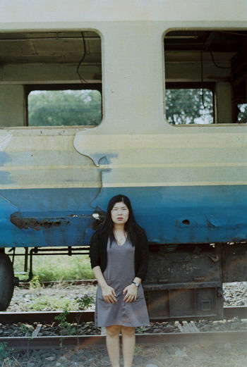 Portrait of young woman sitting on railroad track