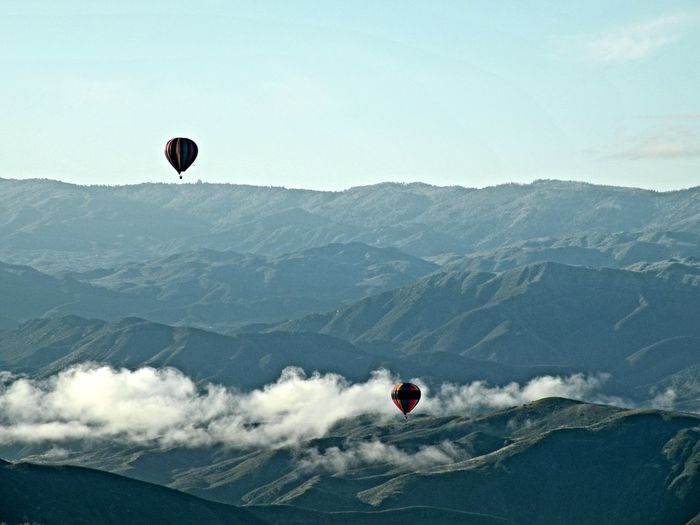 Kite flying over mountains against sky