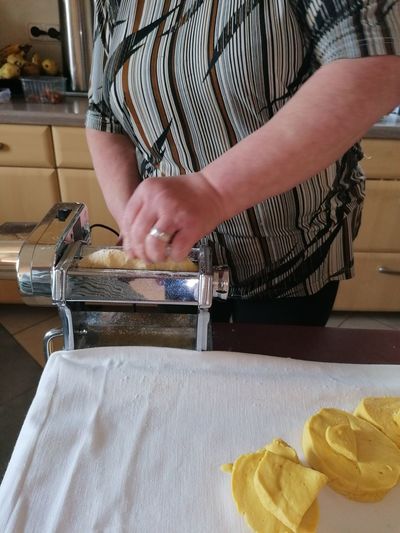 Midsection of woman preparing pasta in home