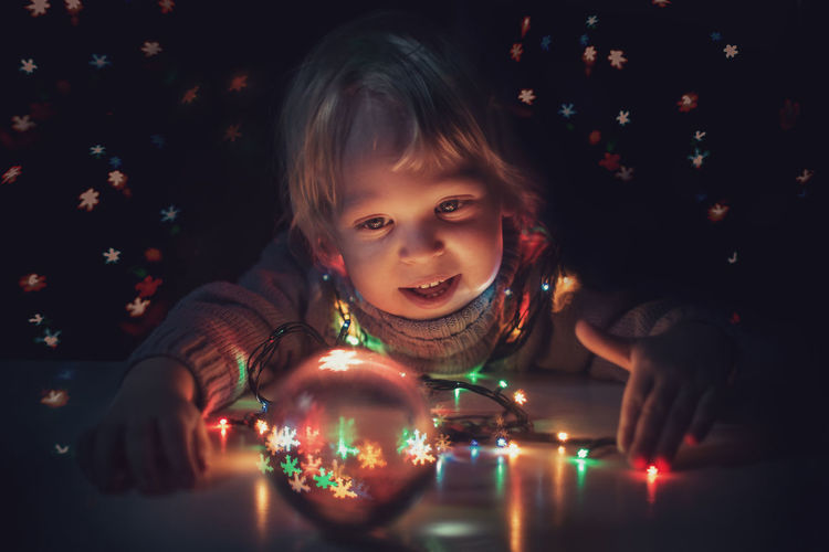 Portrait of girl looking at illuminated christmas lights