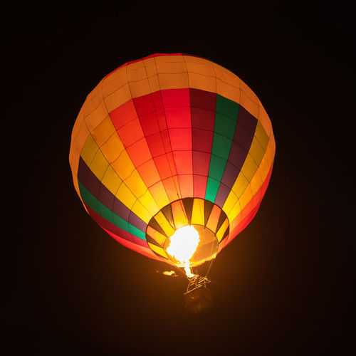 Low angle view of hot air balloons against sky at night