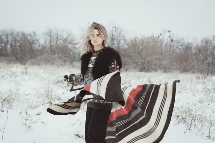 Young woman with woolen plaid in winter field scenic photography