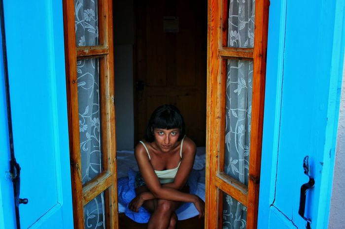 YOUNG WOMAN WITH CLOSED DOOR