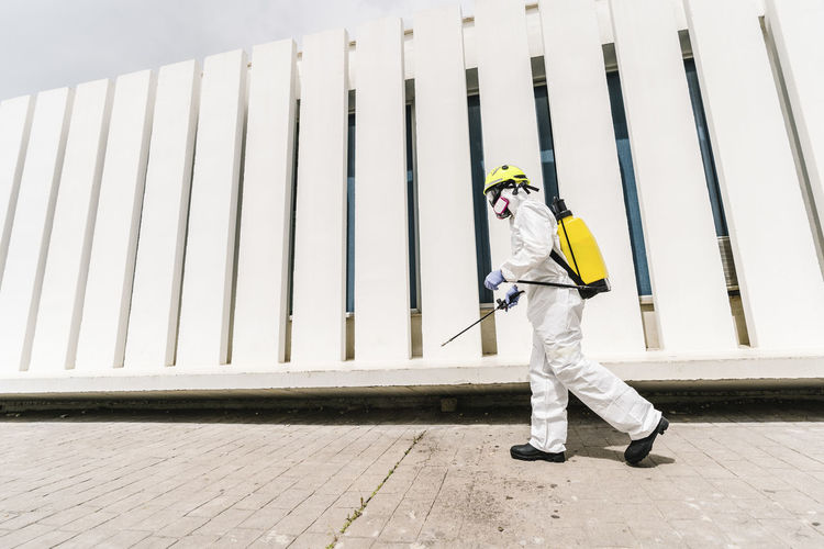 Firefighter disinfecting walls and floors on the street